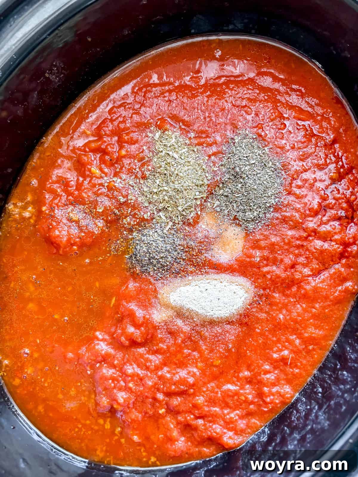 Meaty Slow Cooker Spaghetti Sauce 8 All ingredients for slow cooker spaghetti sauce being combined in a slow cooker.
