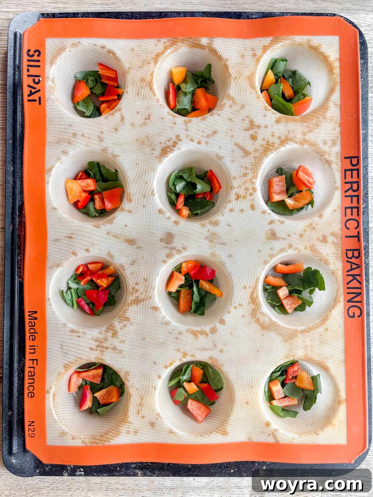 High-Protein Cottage Cheese Egg Bites with Spinach & Pepper 4 Red pepper and spinach in muffin tins.